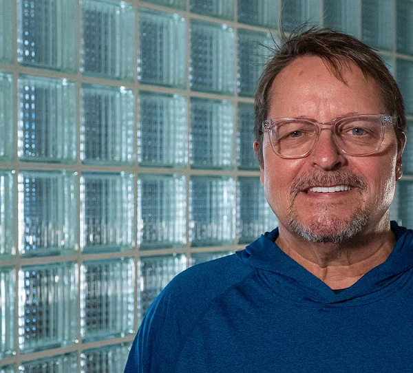 Smiling patient in glasses and a blue sweater
